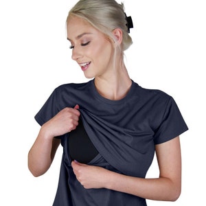 May include: A dark navy blue short-sleeved t-shirt featuring a crew neckline and a layered design that lifts at the chest to reveal a solid black inner panel. The garment is constructed with a smooth, opaque fabric and a standard fit.