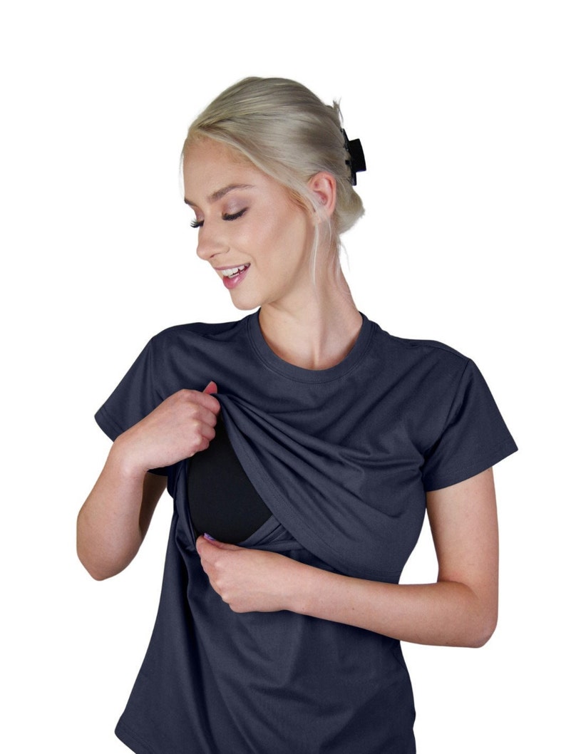 May include: A dark navy blue short-sleeved t-shirt featuring a crew neckline and a layered design that lifts at the chest to reveal a solid black inner panel. The garment is constructed with a smooth, opaque fabric and a standard fit.