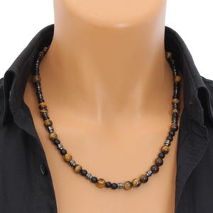 May include: A necklace made of tiger's eye and hematite beads. The beads are brown, gold, and black.