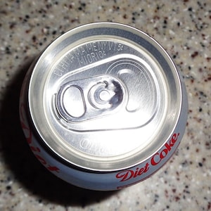 Factory sealed diet coke can mostly empty with about 1/2 oz coke and mostly air.