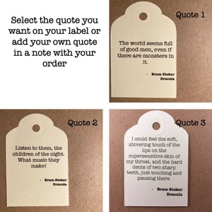 May include: Three white tags with rounded corners and holes at the top. Each tag has a quote from Bram Stoker's Dracula printed on it. The first tag says "The world seems full of good men, even if there are monsters in it." The second tag says "Listen to them, the children of the night. What music they make!" The third tag says "I could feel the soft, shivering touch of the lips on the supersensitive skin of my throat, and the hard dents of two sharp teeth, just touching and pausing there."