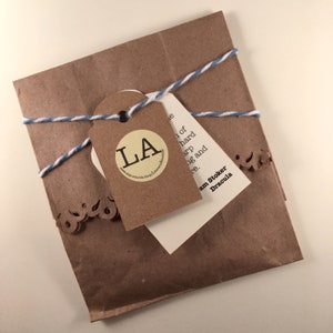 May include: A brown paper package tied with blue and white twine. A white tag with the text "Bram Stoker Dracula" is attached to the package. A smaller tag with a circle containing the letters "LA" is also attached.