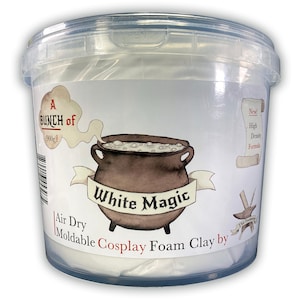 May include: A white plastic bucket with a label that says "A Bunch of 900g! White Magic Air Dry Moldable Cosplay Foam Clay by The Foundry". The label has a cartoon illustration of a cauldron with steam coming out of it.