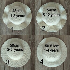 May include: Four straw hats in different sizes for children. The hats are white and have different sizes and age recommendations printed on them. The hats are numbered 1 through 4.