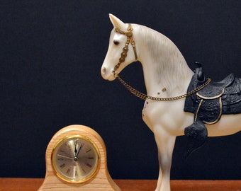 Miniature table clock to please rodeo lover or ranch person watchface. featuring a charm of a horse within a spur on a silver e.g.o