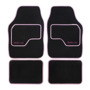 May include: Set of four black car floor mats with pink edging and the text "Beth's Car" embroidered on the front two mats.