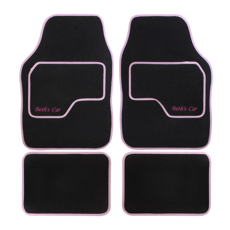 May include: Set of four black car floor mats with pink edging and the text "Beth's Car" embroidered on the front two mats.