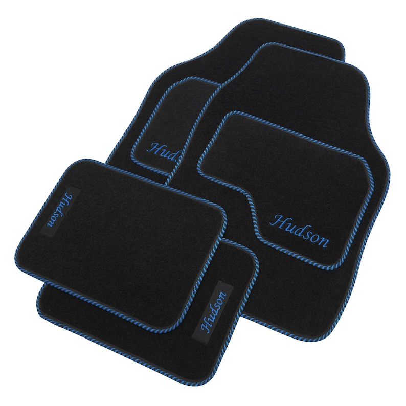 May include: Set of four black car floor mats with blue edging and the name "Hudson" embroidered in blue on each mat.