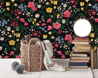 May include: A black and white floral wallpaper with a framed illustration of a deer skull, a round mirror, a wicker basket, and a stack of books.