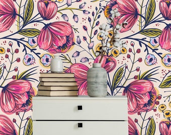 May include: A white dresser with six drawers sits in front of a wall covered in pink and green floral wallpaper. The wallpaper features a repeating pattern of pink flowers with green leaves and stems.