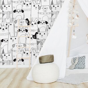 May include: A white teepee tent with a black and white dog pattern wallpaper in the background. The teepee is decorated with a white string of beads and a white fluffy rug. There is a small wooden stool and a plush toy in the teepee.