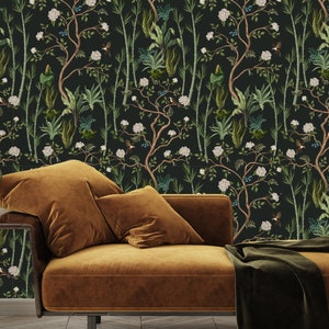 May include: A dark green wallpaper with a repeating pattern of white flowers, green leaves, and brown branches. The wallpaper is shown in a room with a brown couch and a green plant in a woven basket.