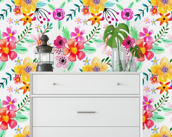 May include: White dresser with three drawers against a white wall with a floral wallpaper pattern. The wallpaper features a variety of flowers in shades of pink, yellow, orange, and green.
