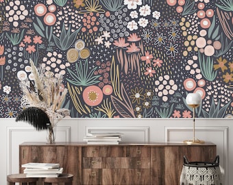May include: A dark gray wall with a floral wallpaper featuring pink, white, and yellow flowers and leaves. A wooden dresser with two small wooden stools sits in front of the wall. A black and white woven basket sits on the floor next to the dresser.