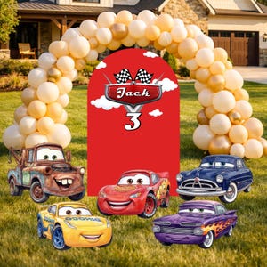 May include: A birthday party scene with a red backdrop featuring the name "Jack" and the number "3", surrounded by a balloon arch. Several cartoon car characters are arranged on the grass, including a rusty tow truck and a red race car.