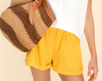 Pantaloncini in lino naturale. Pantaloncini elastici in vita in lino in giallo. Pantaloncini estivi in lino per donna elastico in vita. Pantaloncini di lino con sacchetto di carta.