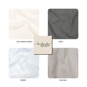 K&ouml;nnte beinhalten: Eine Sammlung von vier Stoffmustern in den Farben Off-White, Grau, Wei&szlig; und Natur. Ein zentrales quadratisches Etikett zeigt den Text "handmade WITH LOVE" mit einem kleinen Herzsymbol. Jeder Stoff weist eine weiche, knittrige Textur auf.