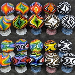 May include: A collection of 20 colorful glass marbles with swirling patterns. The marbles are arranged in two rows of ten, with each marble resting on a small stand.