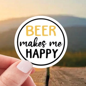 May include: White round sticker with black text that reads "Beer makes me happy". The word "Beer" is in gold.