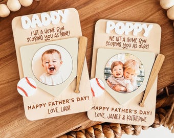 May include: Two wooden baseball-themed Father's Day gifts. One says "Daddy" and the other says "Poppy". Each has a photo, baseball, and bat. The "Daddy" gift says "I hit a home run scoring you as mine!" and "Happy Father's Day! Love, Liam".