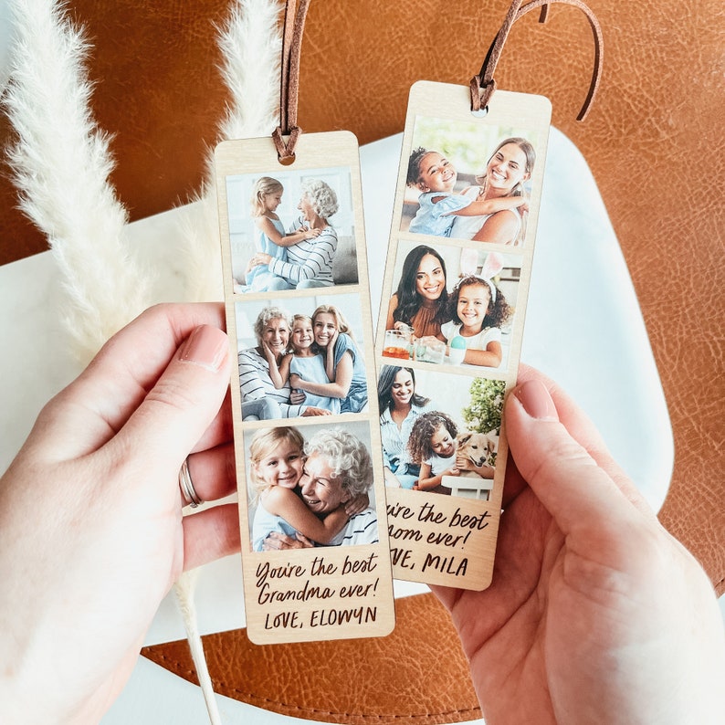 May include: A wooden bookmark with a photo strip design featuring four photos of a grandmother and granddaughter. The bookmark has a handwritten message that reads "You're the best Grandma ever! Love, Elowyn".