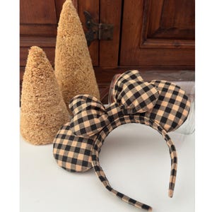 May include: A black and tan gingham headband with large bow and mouse ears.