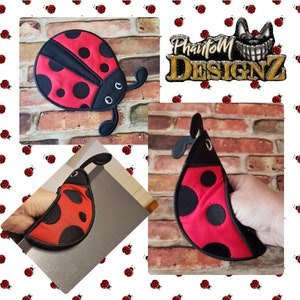 May include: A red and black ladybug-shaped pot holder with black spots and antennae. The pot holder is made of fabric and has a loop for hanging. The image also includes a logo that says "Phantom Designz".
