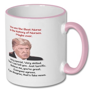 May include: White ceramic coffee mug with a pink rim and handle. The mug features a cartoon image of Donald Trump and the text "You are the Best Nurse in the history of Nurses. Maybe ever. Very special. Very skilled. That I can tell you. Just terrific. Believe me, you're great. Everyone agrees. If you disagree, that's fake news."