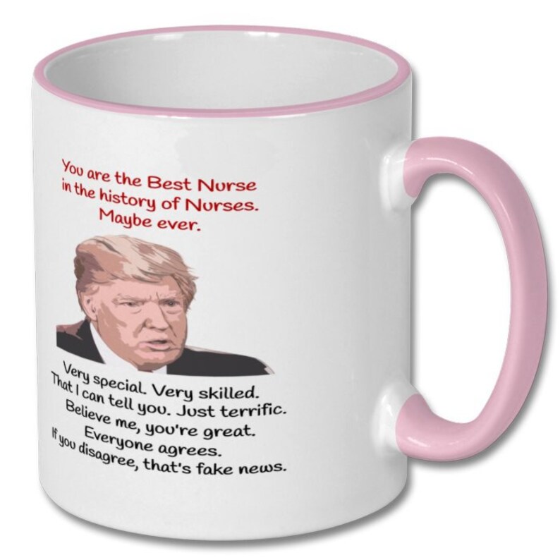 May include: White ceramic coffee mug with a pink rim and handle. The mug features a cartoon image of Donald Trump and the text "You are the Best Nurse in the history of Nurses. Maybe ever. Very special. Very skilled. That I can tell you. Just terrific. Believe me, you're great. Everyone agrees. If you disagree, that's fake news."