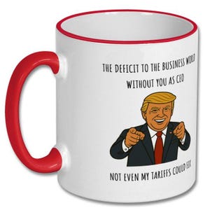 May include: White ceramic mug with a red handle and rim. The mug features a cartoon illustration of a man in a suit, pointing. Text on the mug reads: "THE DEFICIT TO THE BUSINESS WORLD WITHOUT YOU AS CEO NOT EVEN MY TARIFFS COULD FIX."