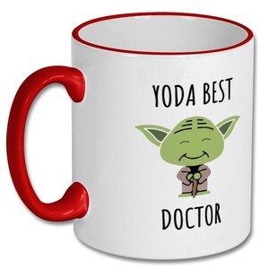 May include: White ceramic mug with a red rim and handle. The mug features a cartoon image of Yoda with the text "Yoda Best Doctor".