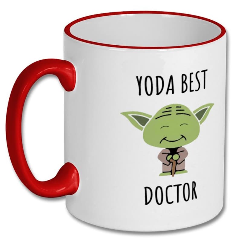 May include: White ceramic mug with a red rim and handle. The mug features a cartoon image of Yoda with the text "Yoda Best Doctor".