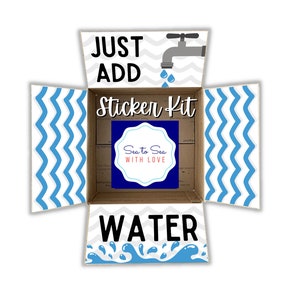 May include: A cardboard box with a blue and white chevron pattern on the sides. The box is open and the inside is labeled "Just Add Water Sticker Kit". The box is decorated with a blue and white chevron pattern and a blue and white sticker that says "Sea to Sea with Love".