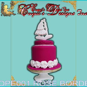 Könnte beinhalten: Eine zweistöckige Hochzeitstorte mit einem rosa Fondant-Sockel und weißen Fondant-Rosen um die untere Etage. Die Torte ist mit einer weißen Fondant-Braut- und Bräutigamfigur verziert. Die Torte steht auf einem weißen Tortenständer. "SOPE001 ROSE BORDER" ist in goldenen Buchstaben am unteren Rand des Bildes geschrieben.