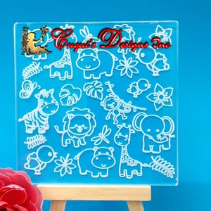 Puede incluir: Una plancha de sellos de acrílico transparente con un diseño blanco de varios animales de la selva, incluyendo una jirafa, una cebra, un león, un elefante, un hipopótamo y un mono. El diseño también incluye flores, hojas y un pájaro.