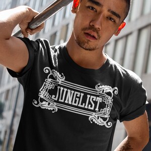 May include: A black t-shirt with a white graphic design that says "JUNGLIST" in a decorative font.