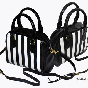 May include: Two black and white striped handbags with gold hardware and black shoulder straps. *Sold Individually*