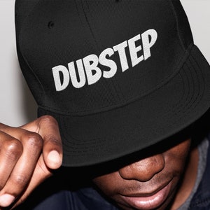 May include: A black and white baseball cap with the word "DUBSTEP" embroidered in white on the front.
