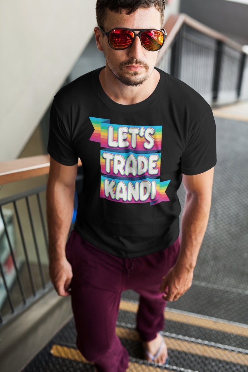 May include: A black t-shirt with a rainbow banner that says "Let's Trade Kandi".