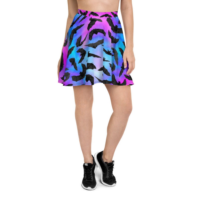 May include: A short, blue, pink, and purple skater skirt with a black bat print. The skirt is made of a soft, stretchy fabric and has a comfortable fit.