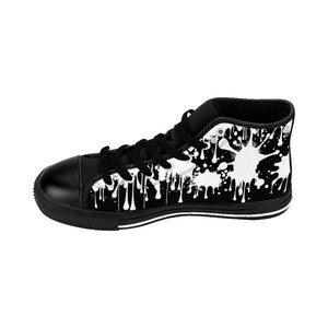May include: Black high-top canvas sneakers with a white paint splatter design. The sneakers have a black rubber sole and white stitching.
