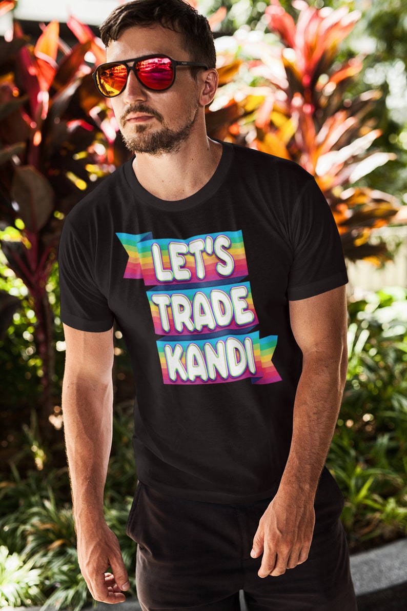 May include: A black t-shirt with a rainbow-colored banner that says "Let's Trade Kandi".