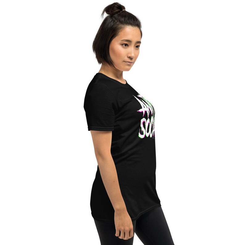 Puede incluir: Una camiseta negra con un gr&aacute;fico blanco que dice "Live Your Truth" en una fuente distorsionada con acentos verdes y morados.