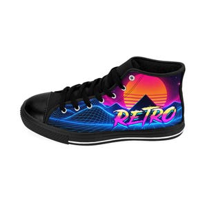 Puede incluir: Una zapatilla alta negra con un estampado gr&aacute;fico vibrante de una puesta de sol de ne&oacute;n sobre un paisaje monta&ntilde;oso de rejilla azul. La palabra RETRO est&aacute; impresa en una fuente estilizada de color rosa y amarillo en el lateral, con cordones negros.