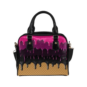 Puede incluir: Bolso negro con un dise&ntilde;o de cono de helado rosa y negro que gotea sobre un fondo de cono de waffle.