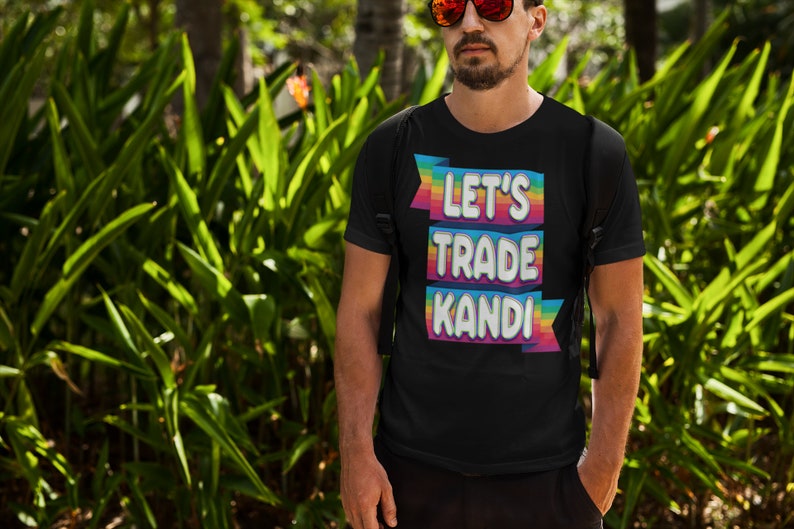 May include: A black t-shirt with a rainbow-colored graphic that says "Let's Trade Kandi".
