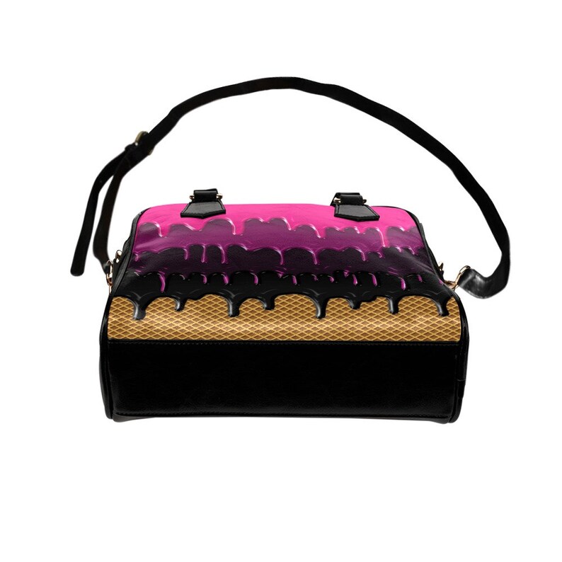 Puede incluir: Un bolso negro con un dise&ntilde;o de cono de helado rosa y negro. El bolso tiene un asa superior y una correa para el hombro.