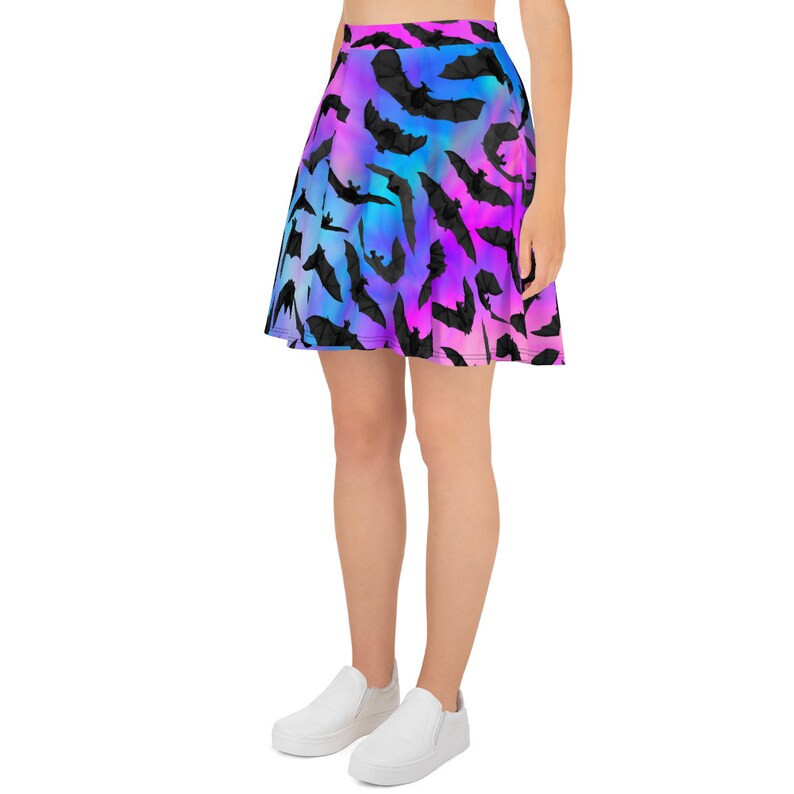 May include: A skater skirt with a black bat silhouette pattern on a gradient background of pink, blue, and purple.