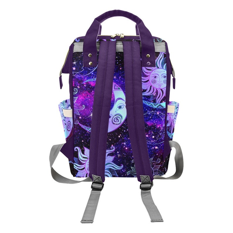 May include: Purple backpack with adjustable straps. The backpack has a galaxy print with moons and suns in a blue and white color scheme.