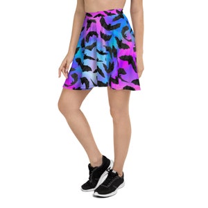 May include: A skater skirt with a colorful ombre pattern featuring black bats. The skirt is made of a soft, stretchy fabric and has a comfortable fit.